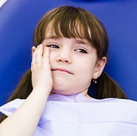 Young girl with toothache holding cheek