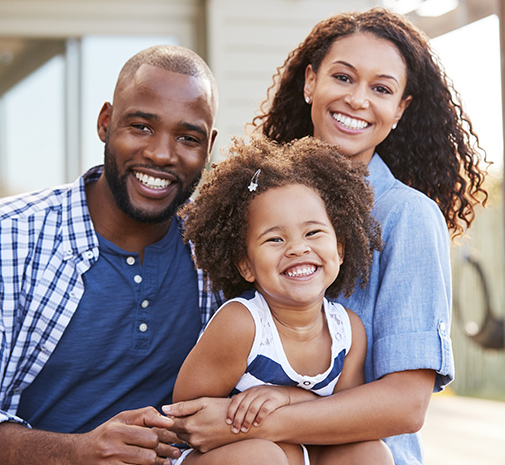 Family smiling after visiting their dentist for dental care