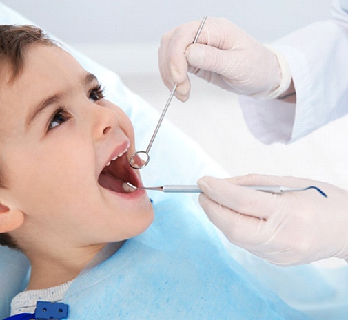 Happy boy getting checkup by pediatric dentist in Grayslake