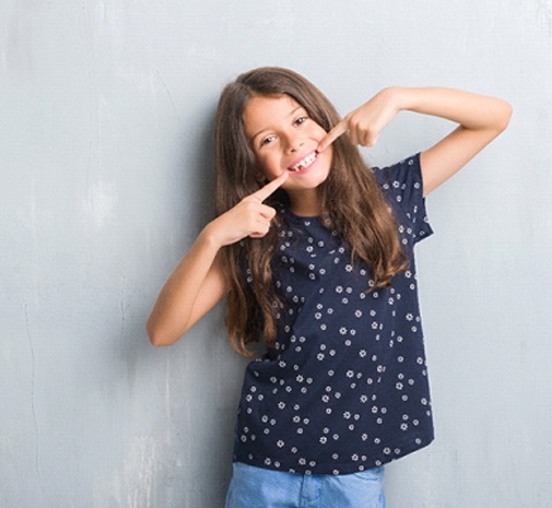 Young girl pointing to smile in Grayslake