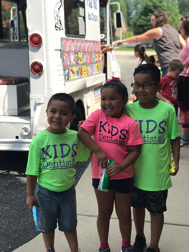 Three kids enjoying treats at ice cream truck event