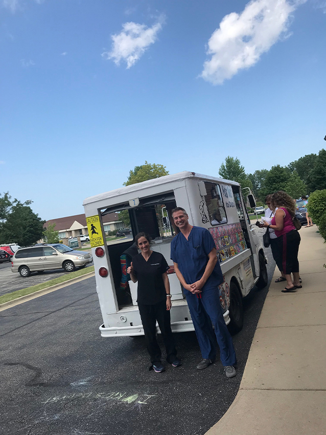 Dental team members standing beside an ice cream truck