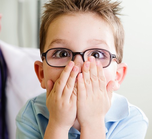 Child covering mouth after dental emergency