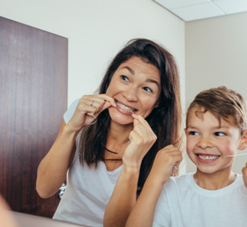 Grayslake child flossing with parent after tooth extraction