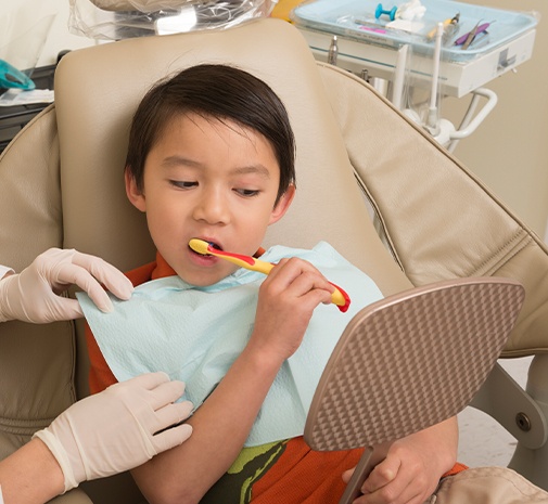 Child brushing teeth during gum disease treatment visit