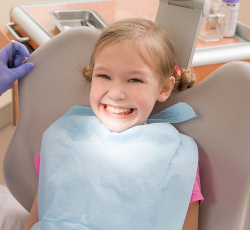 Young child smiling after dental sealant treatment