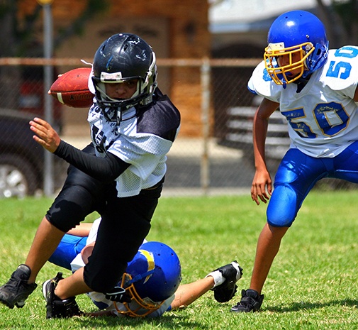 Children playing football with athletic mouthguards