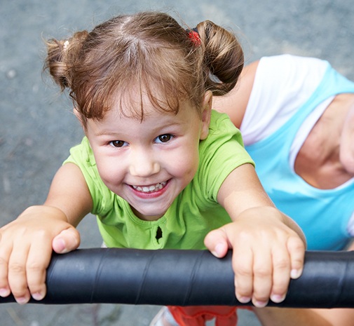 Little girl playing outdoors after silver diamine fluoride treatment