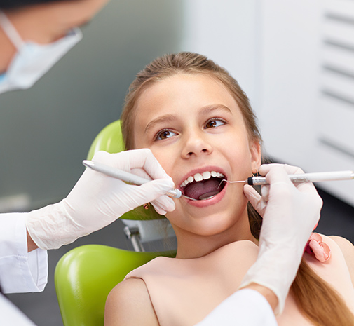 Patient examining child's bright smile after she used at home teeth whitening kit