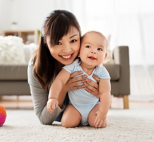 Mother and baby smiling after dentistry for infants