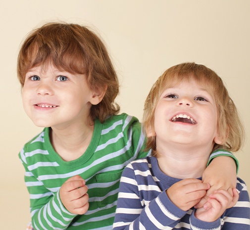 Two kids smiling after dentistry for children