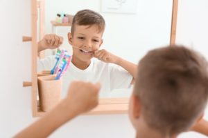 young boy learning how to floss