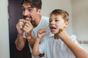 dad showing his skills in teaching kids how to floss