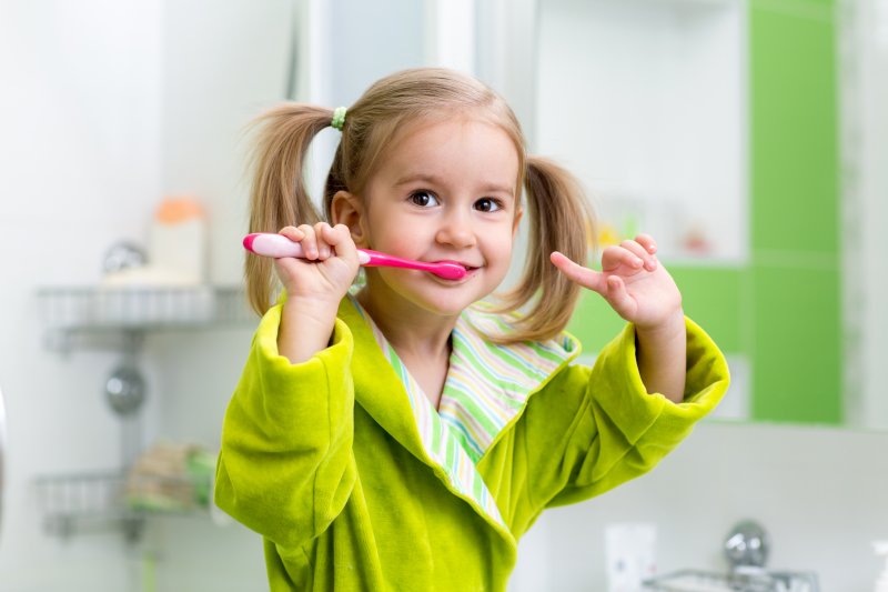 little girl brushing her teeth