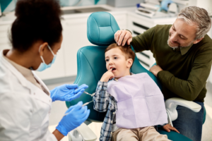 a parent watching their child receive dental treatment