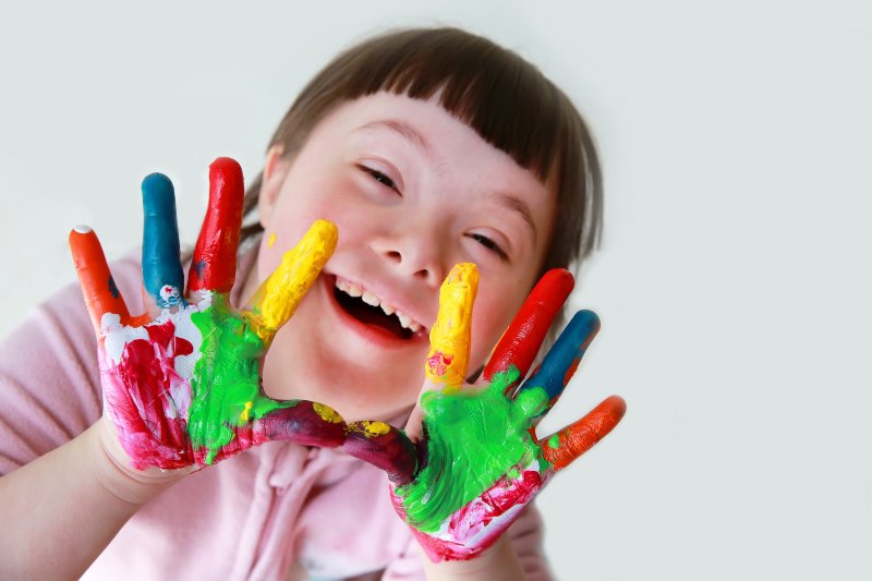 young girl with Down syndrome and painted hands