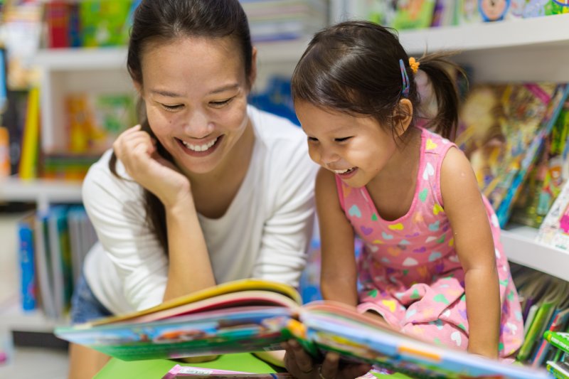 a mother and child reading a book together