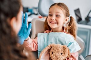 Happy child high-fiving a member of her dental team