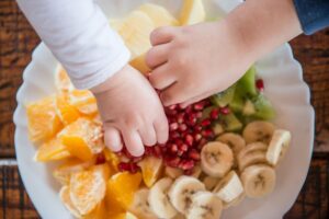 Children eating from a plate of fruit